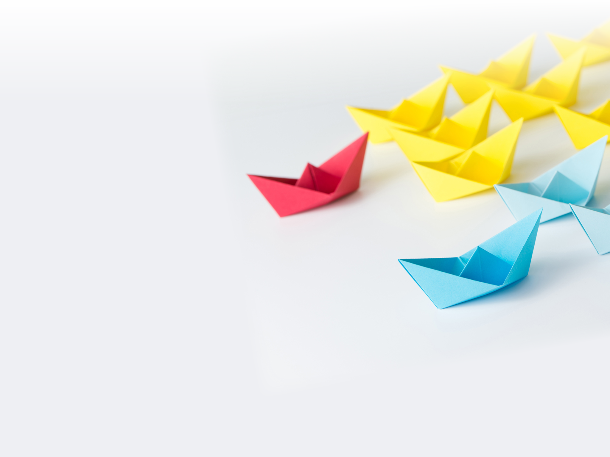 Business competition concept using two different color origami paper boats