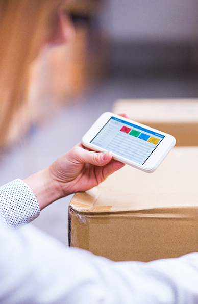 Young woman warehouse worker or supervisor with smartphone 