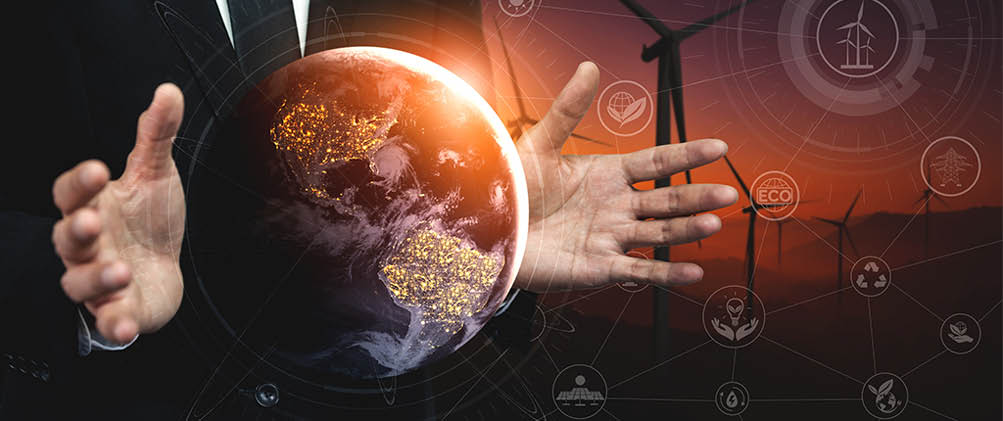 Concept of sustainability development by alternative energy. Man hand take care of planet earth with environmentally friendly wind turbine farm and green renewable energy in background.