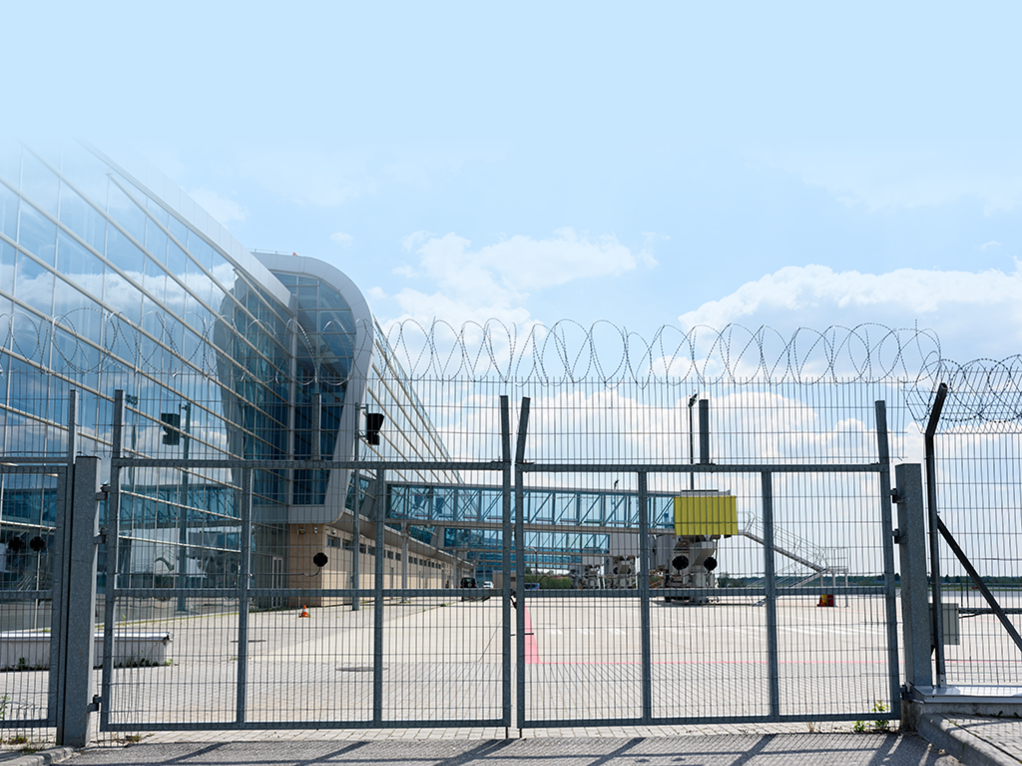 Airport fence grille on the background of passenger bridges for boarding passengers. Place for the test on the plate.