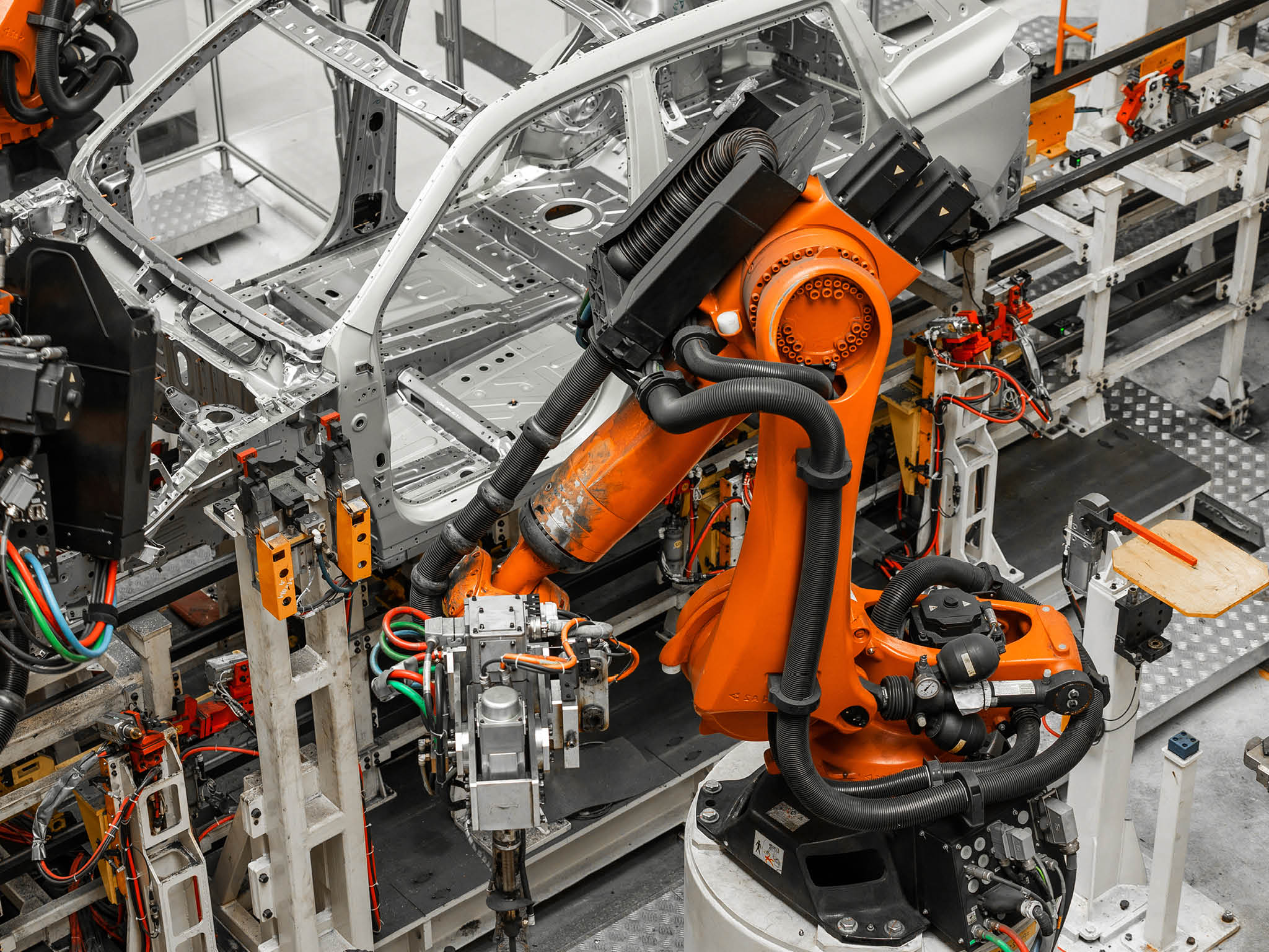 Car bodies are on assembly line. Factory for production of cars. Modern automotive industry. Electric car factory, conveyor.