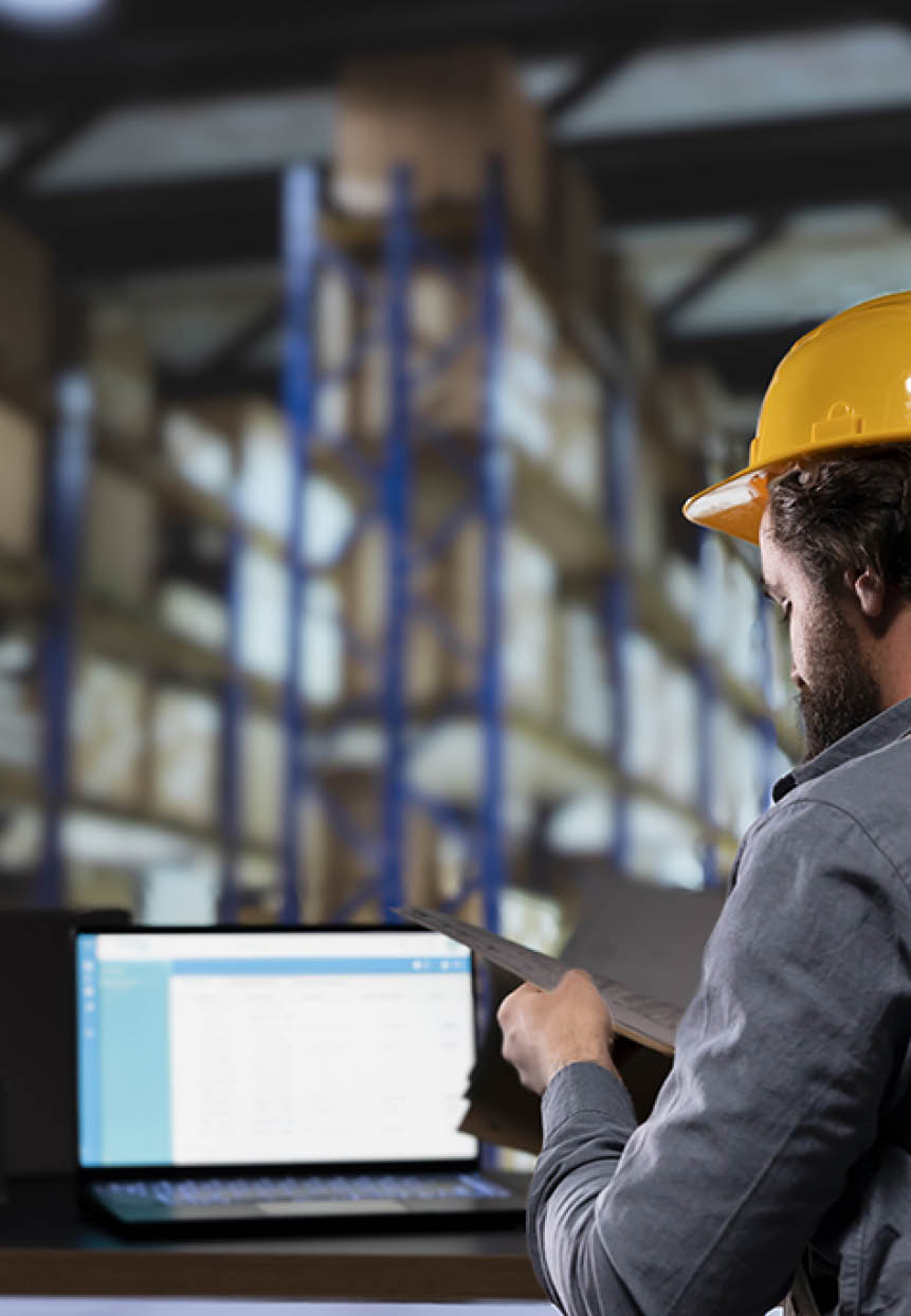 Production supervisor dealing with inventory management in depot, reading list of stock invoices and orders for distribution. Engineer in warehouse planning new merchandise shipment.