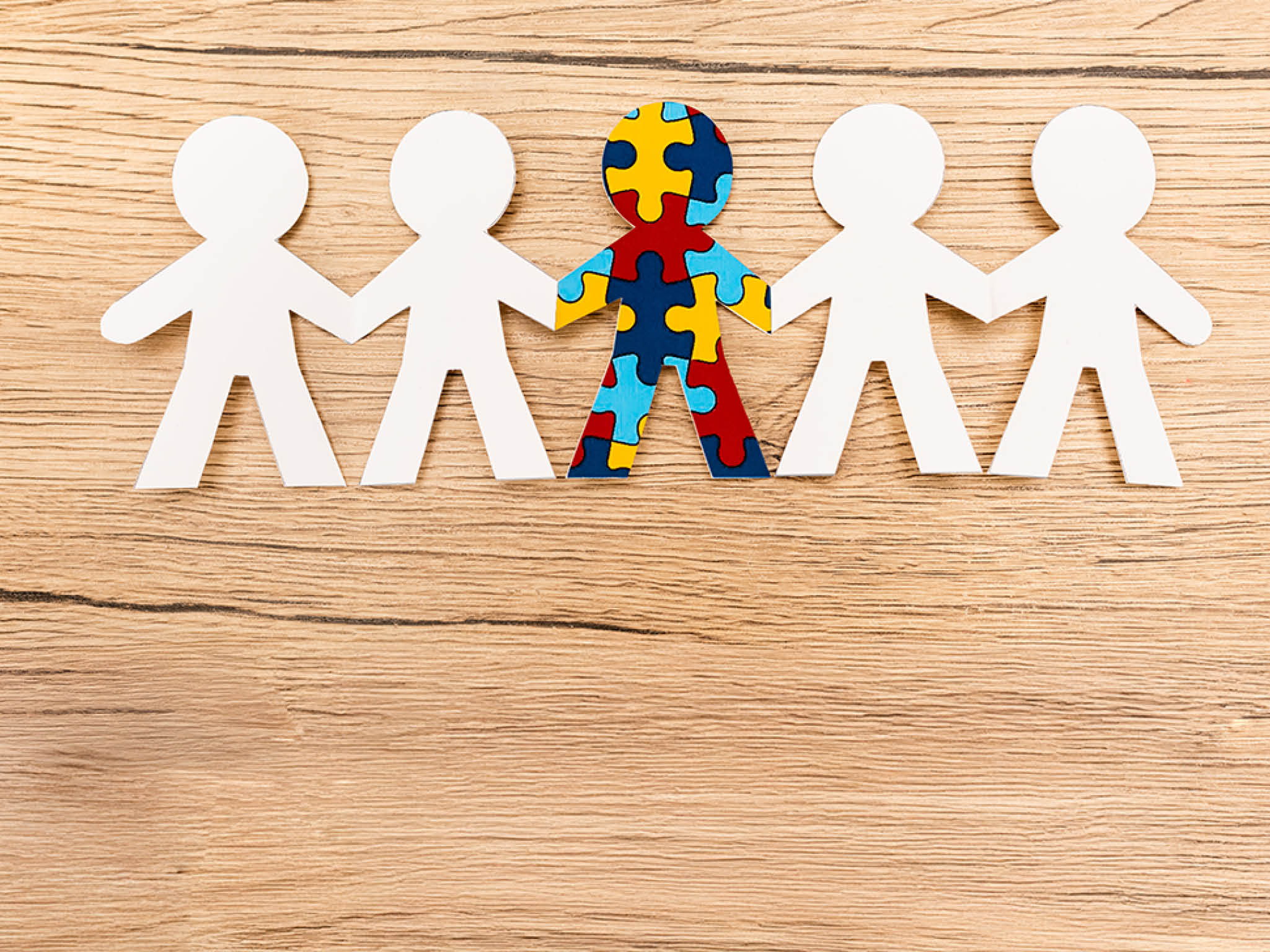 Top view of special kid with autism among another on wooden background